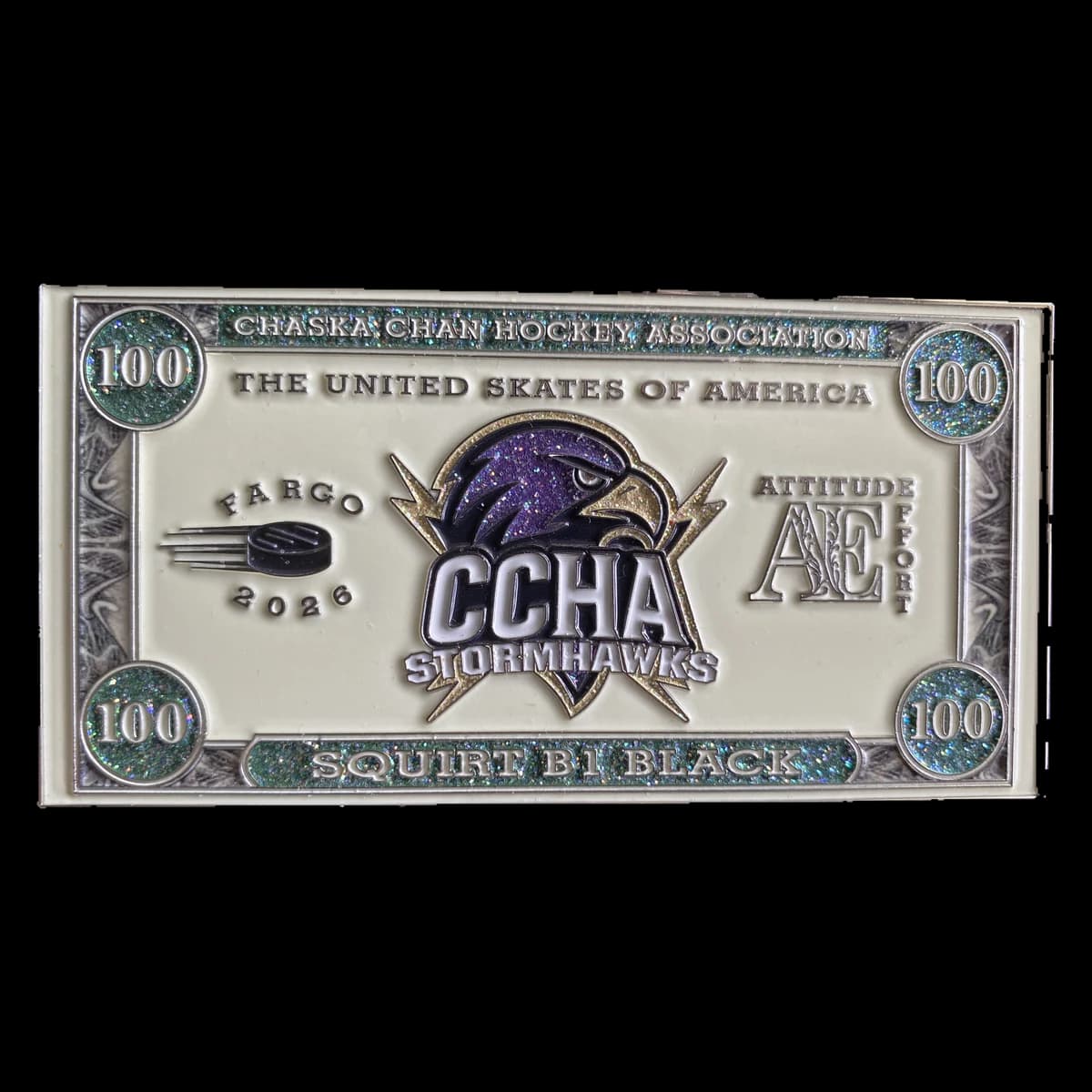 A trading pin shaped like a hundred-dollar bill, with the CCHA Stormhawks hawk in the middle, The United Skates of America across the top, glitter 100s in the corners and Squirt B1 Black along the bottom