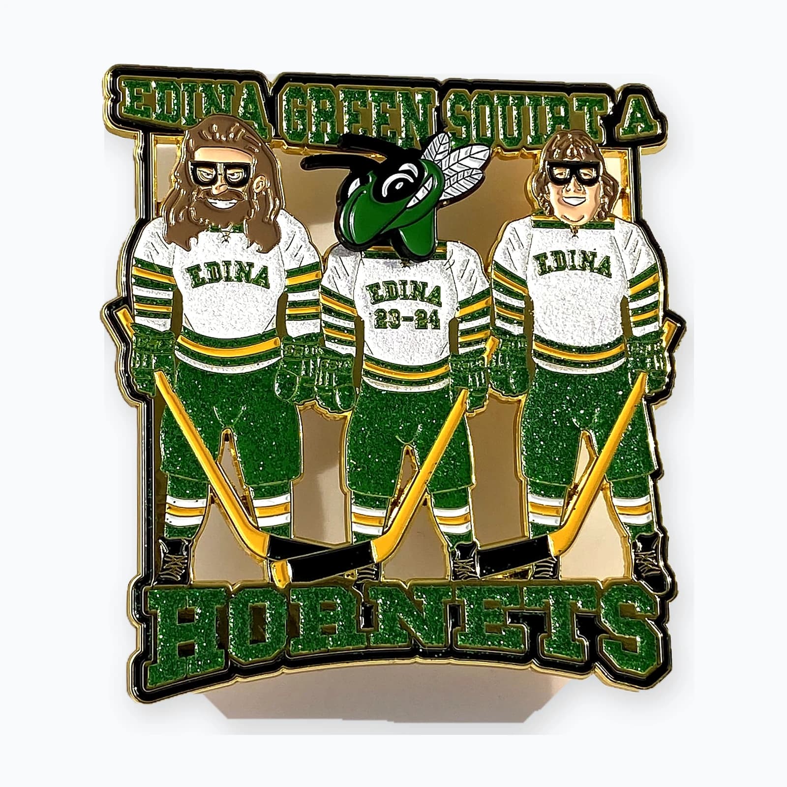 An Edina Hornets trading pin showing three players in green jerseys