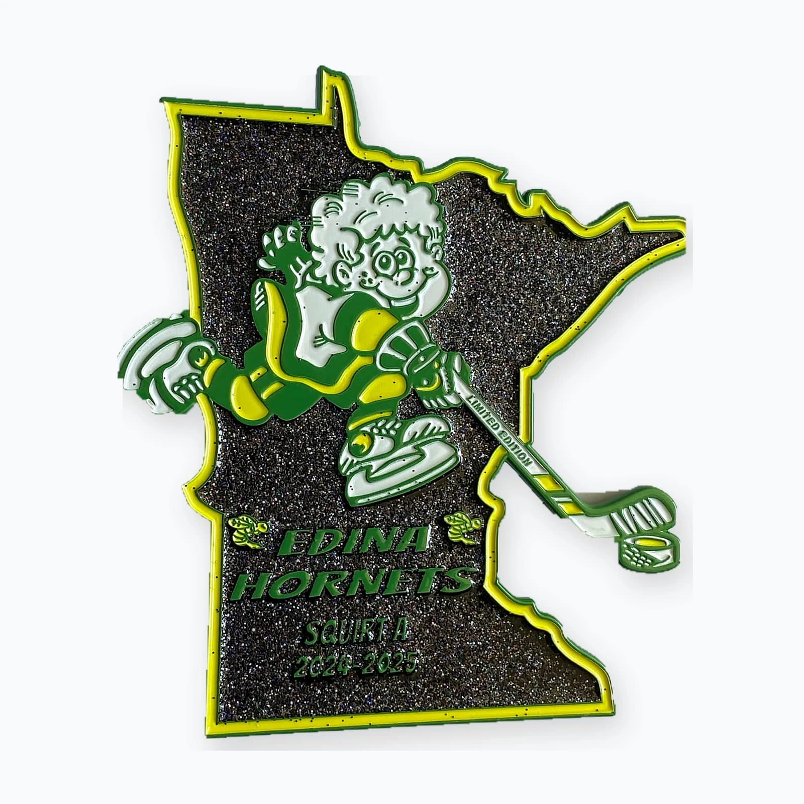 A Minnesota-shaped Edina Hornets pin with a glow-green finish