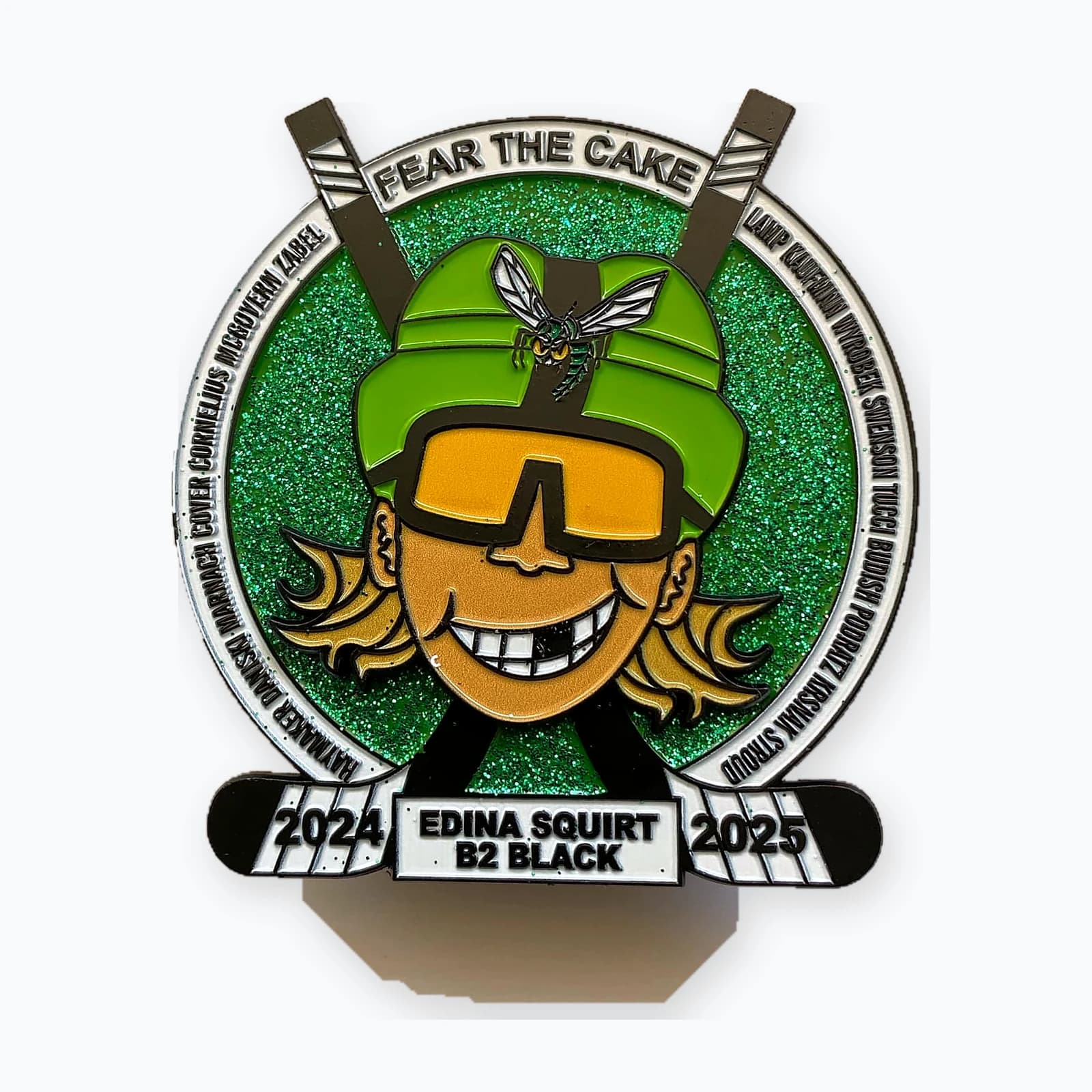 An Edina Squirt B2 trading pin with a green character design