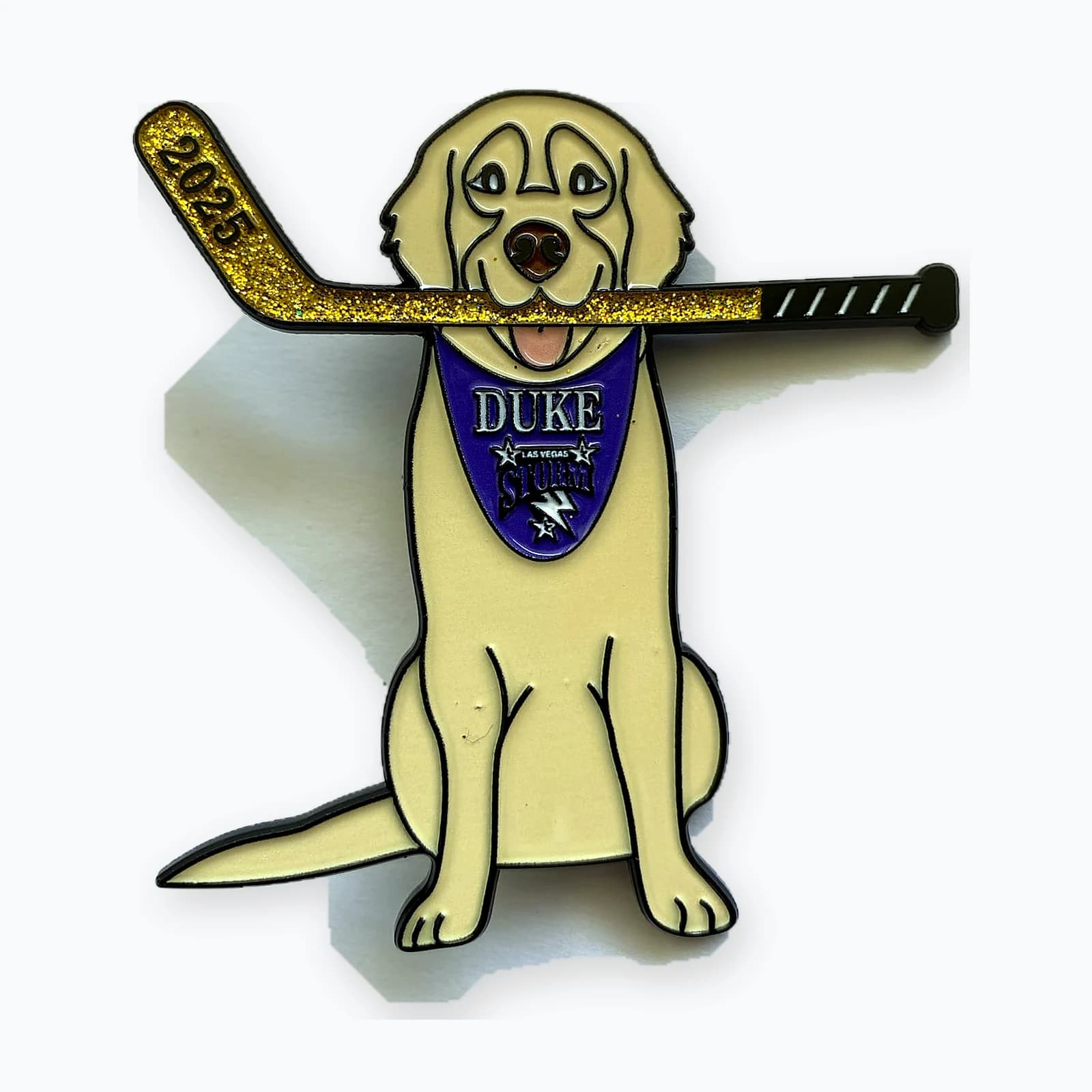 A trading pin shaped like a golden retriever holding a hockey stick